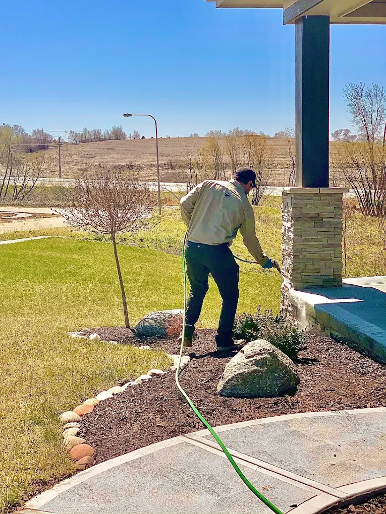 RECON Pest Services technician applying a mosquito control treatment around the exterior of a residential home to reduce mosquitoes and create a more comfortable outdoor living space.